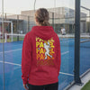 Woman wearing red Padel graphic hoodie on outdoor court, back view showing bold yellow and orange 'PADEL PADEL PADEL' design with player silhouette